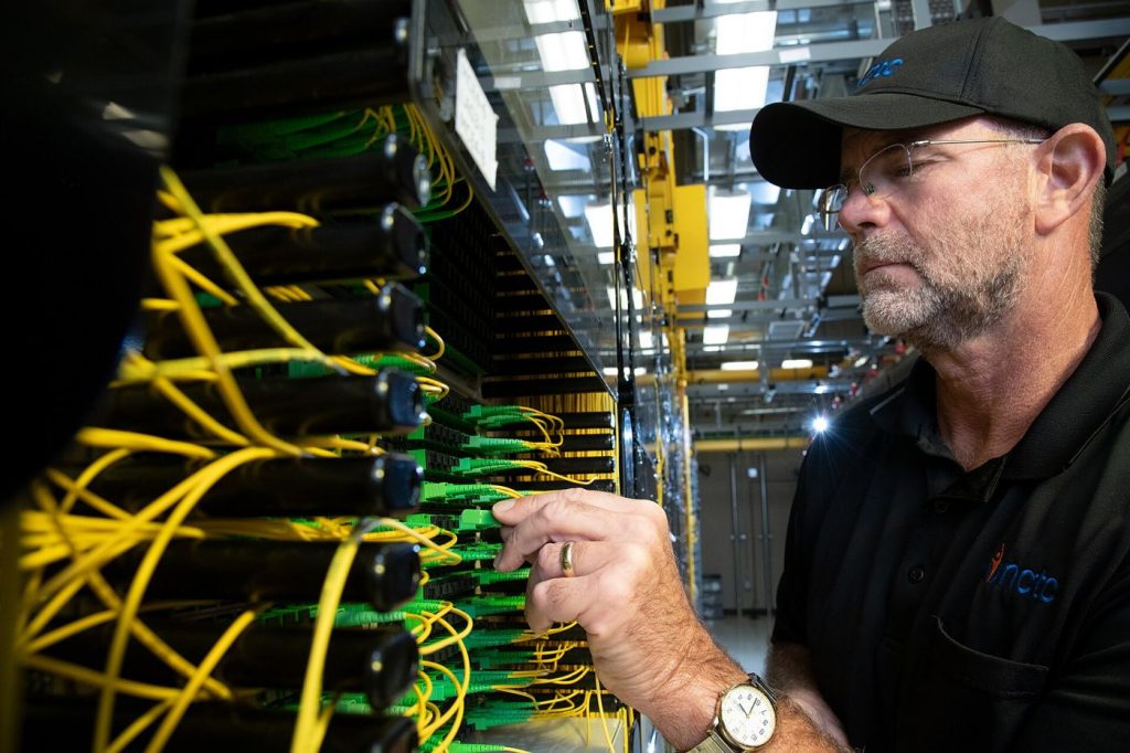 Fiber Crews Race to Bring Fast Broadband to Villages A technician splicing bright fiber optic cables during a broadband installation.
